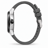 A side profile view of a smartwatch with a dark gray silicone strap and a silver-toned metal case, set against a plain white background.