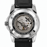 A close-up shot of a wristwatch showing its transparent back case with a visible mechanical movement. The watch has a silver stainless steel case, a black leather strap, and a gold crown, with the brand name 'Kings of Time' visible on the inner dial.